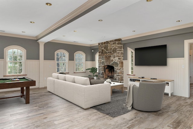 living room featuring billiards, crown molding, light wood-type flooring, a fireplace, and decorative columns