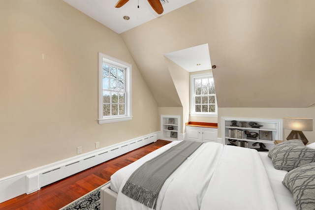 bedroom featuring multiple windows, vaulted ceiling, hardwood / wood-style flooring, and a baseboard heating unit