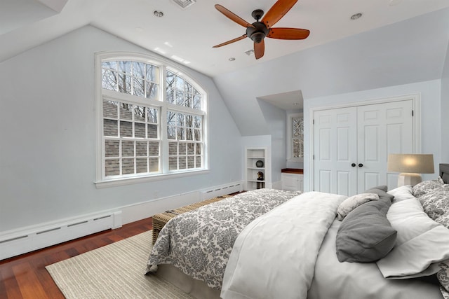 bedroom featuring dark wood-type flooring, lofted ceiling, a baseboard radiator, a closet, and ceiling fan