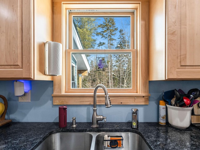 kitchen with sink, dark stone counters, and light brown cabinets