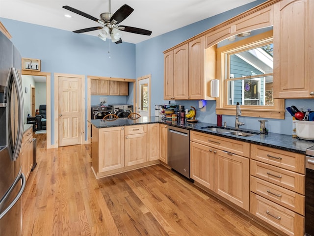 kitchen featuring kitchen peninsula, stainless steel appliances, sink, separate washer and dryer, and light brown cabinetry