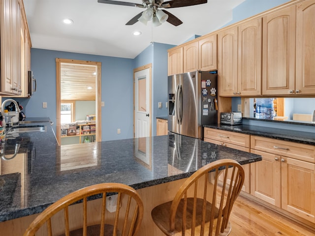 kitchen featuring sink, stainless steel fridge, light brown cabinets, and kitchen peninsula