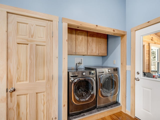 clothes washing area featuring cabinets and washing machine and dryer