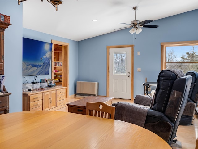 dining room featuring light wood-type flooring, lofted ceiling, and ceiling fan