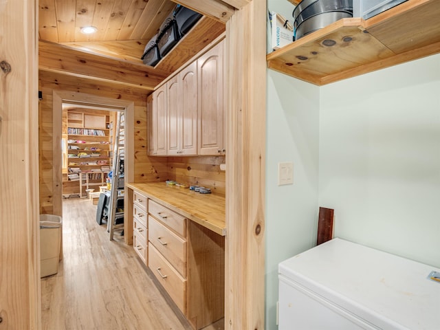 interior space featuring light hardwood / wood-style flooring, wood walls, butcher block countertops, light brown cabinetry, and wood ceiling