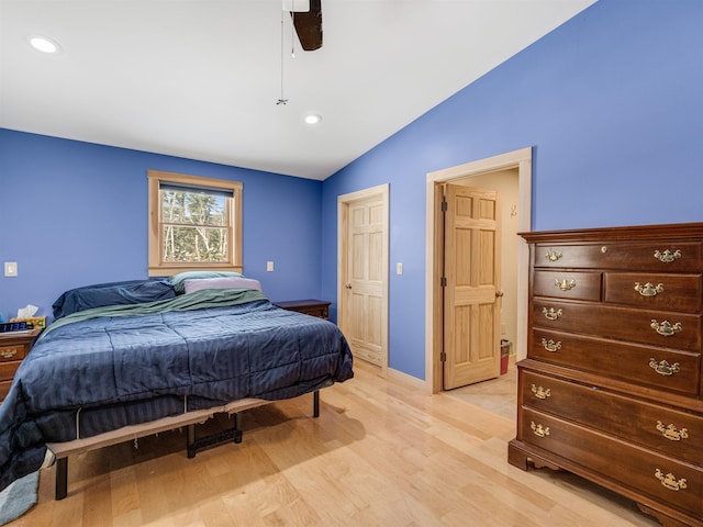 bedroom with light hardwood / wood-style floors, vaulted ceiling, and ceiling fan