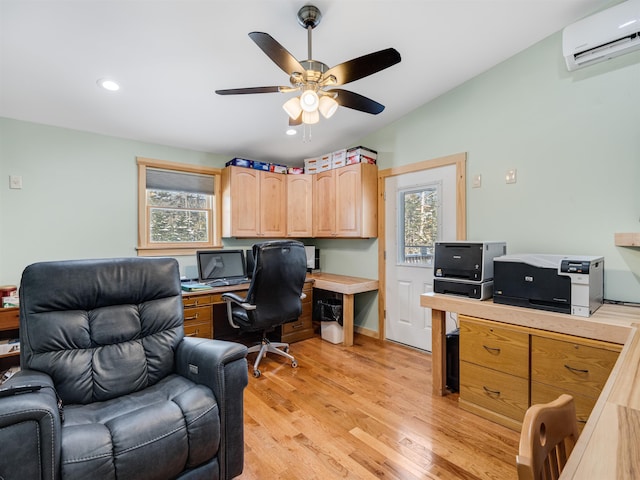 office area featuring a wall mounted air conditioner, light hardwood / wood-style floors, a wealth of natural light, and ceiling fan