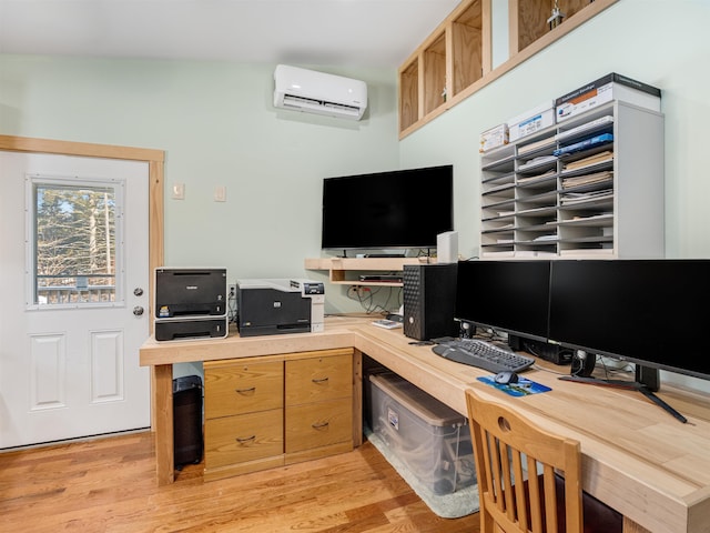 home office featuring light wood-type flooring and a wall mounted air conditioner