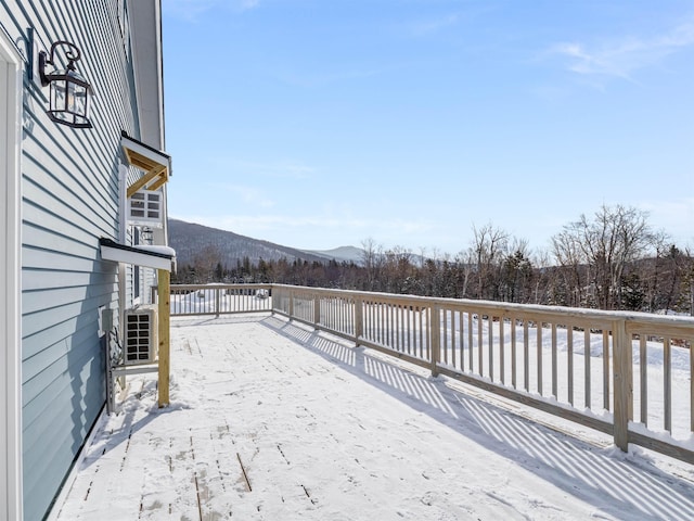 snow covered deck with a mountain view