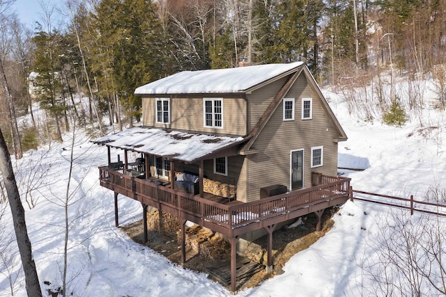 snow covered rear of property featuring a wooden deck