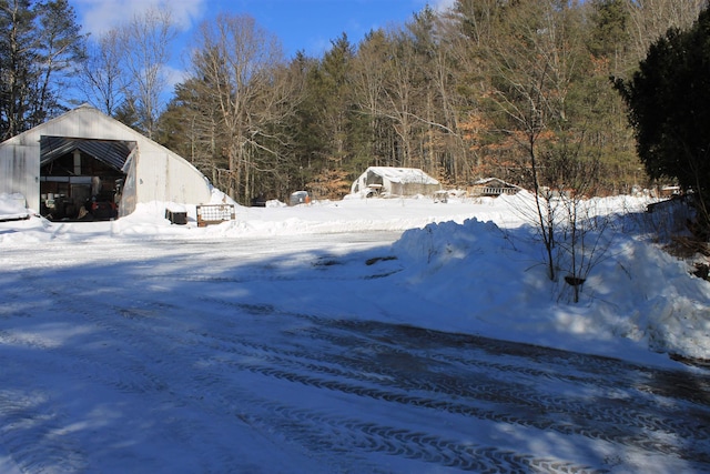 snowy yard featuring an outbuilding