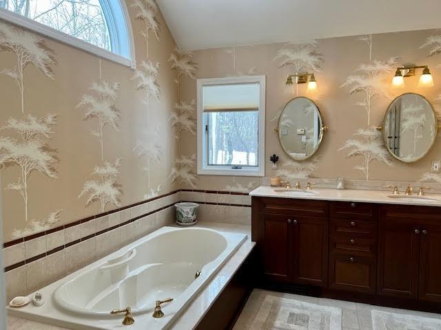 bathroom featuring vanity and a relaxing tiled tub