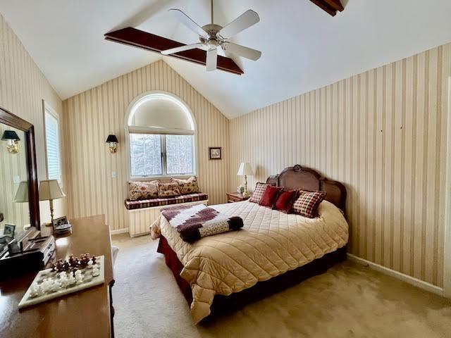 carpeted bedroom featuring ceiling fan and vaulted ceiling