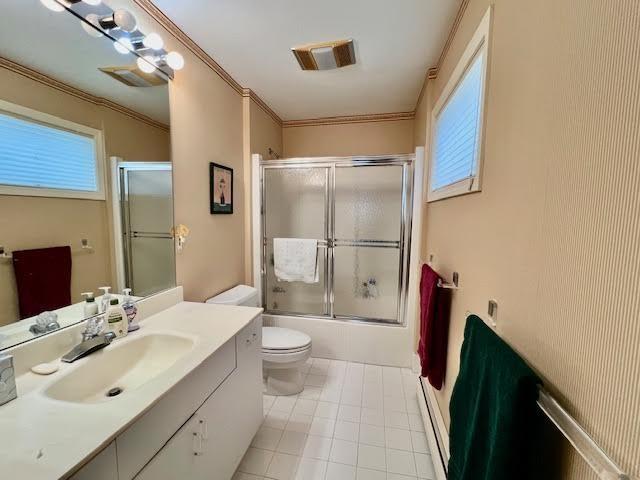 full bathroom with crown molding, combined bath / shower with glass door, vanity, tile patterned floors, and toilet