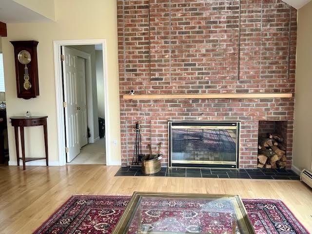 living room with lofted ceiling, hardwood / wood-style floors, and a fireplace