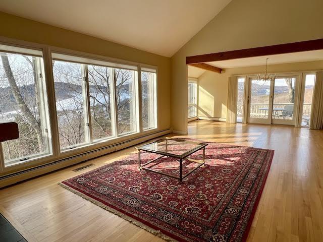 living room with high vaulted ceiling and light hardwood / wood-style floors