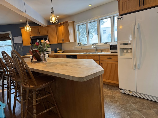 kitchen featuring stainless steel stove, wood counters, sink, hanging light fixtures, and white fridge with ice dispenser