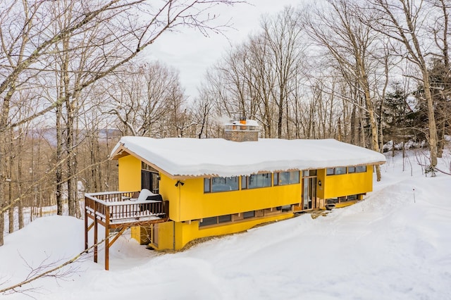 exterior space featuring a wooden deck and a chimney