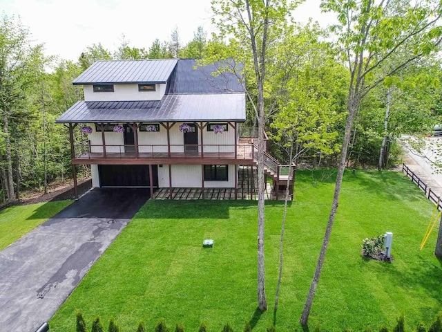 view of front facade with a garage, a front yard, and a deck