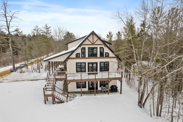 snow covered rear of property with a wooden deck