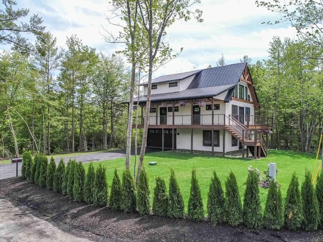 rear view of property with a deck and a lawn