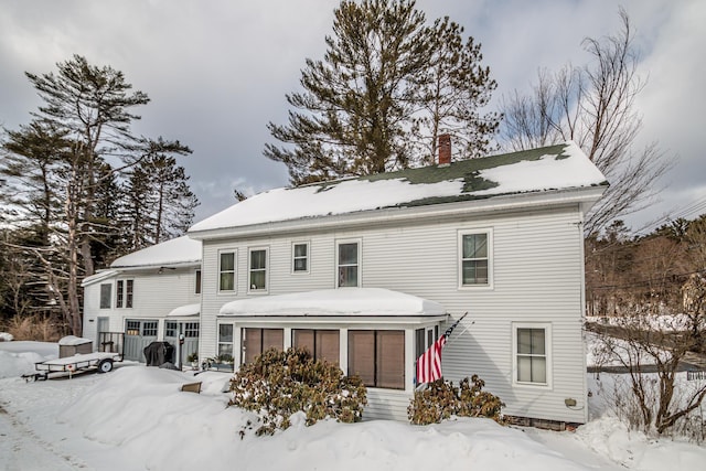 snow covered property featuring a sunroom