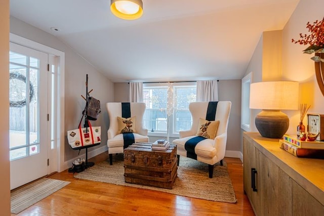 living area with light wood-type flooring and vaulted ceiling