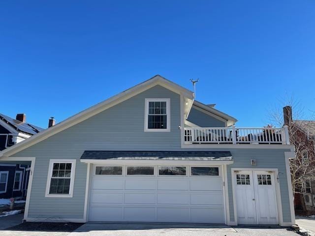 view of side of property with a garage and a balcony