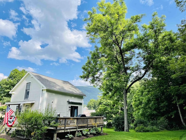 back of property with a yard and a deck