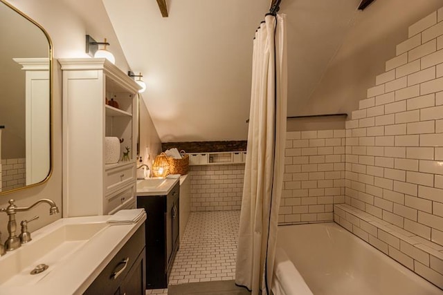 bathroom featuring vaulted ceiling, shower / bath combo with shower curtain, tile patterned flooring, and vanity