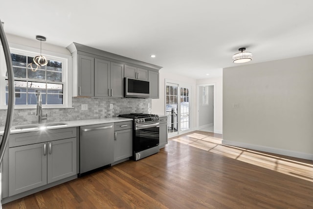 kitchen with gray cabinets, sink, tasteful backsplash, and stainless steel appliances