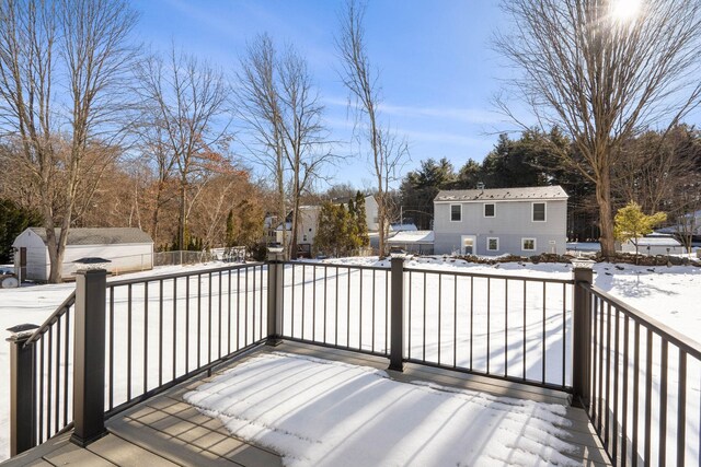 snow covered deck featuring a storage unit