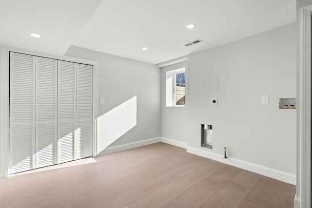 washroom with hookup for a gas dryer, hookup for an electric dryer, washer hookup, and light hardwood / wood-style flooring