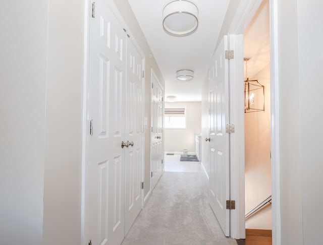 corridor featuring light colored carpet