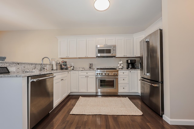 kitchen featuring sink, high quality appliances, light stone countertops, and white cabinets