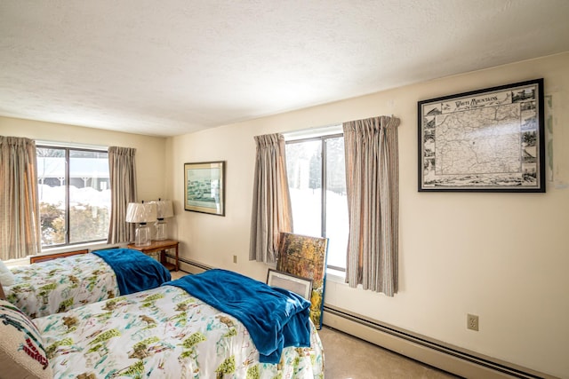 carpeted bedroom with multiple windows, a baseboard heating unit, and a textured ceiling