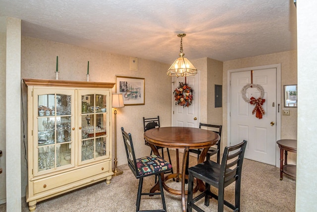 dining area with electric panel, carpet floors, and a textured ceiling