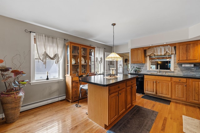 kitchen featuring light wood-type flooring, a kitchen island, pendant lighting, and baseboard heating