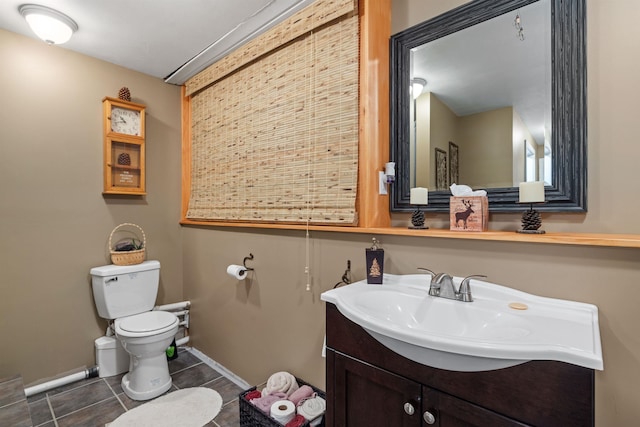 bathroom with toilet, tile patterned flooring, and vanity