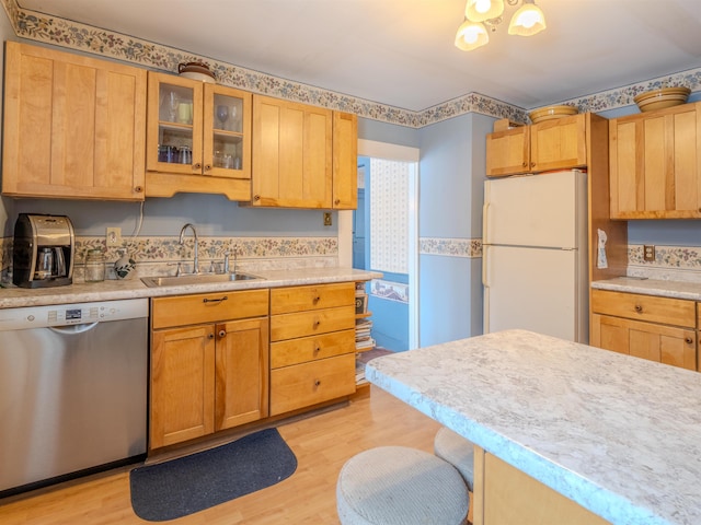 kitchen with a breakfast bar area, stainless steel dishwasher, light hardwood / wood-style floors, white fridge, and sink