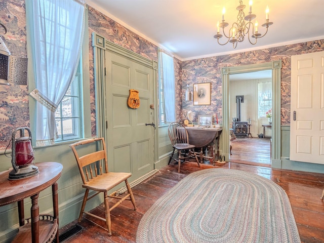 foyer featuring a notable chandelier, dark hardwood / wood-style floors, and a wood stove