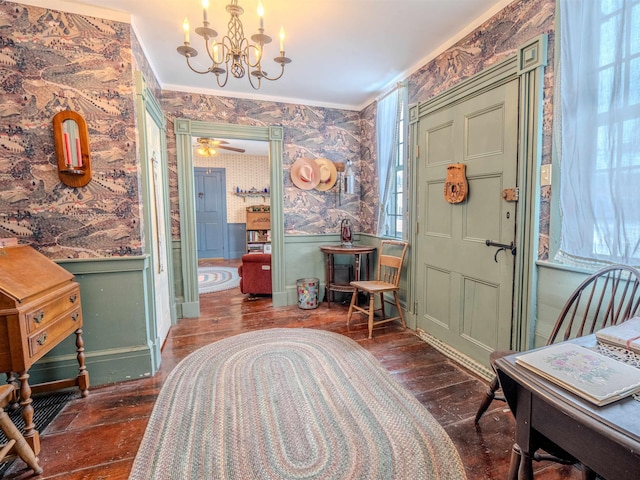 entrance foyer with an inviting chandelier, crown molding, and dark hardwood / wood-style floors