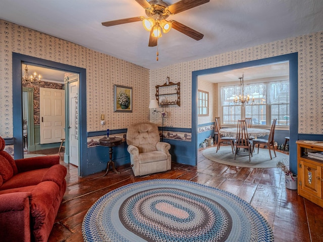 living room featuring ceiling fan with notable chandelier and dark wood-type flooring