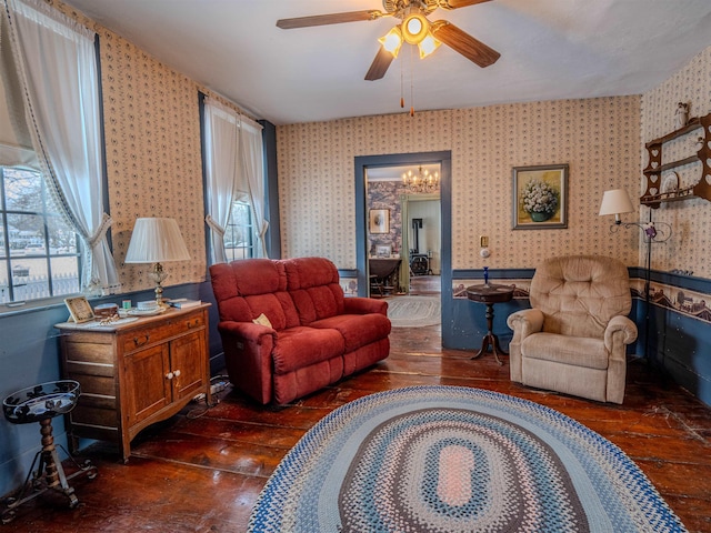 living room with ceiling fan with notable chandelier and dark hardwood / wood-style floors