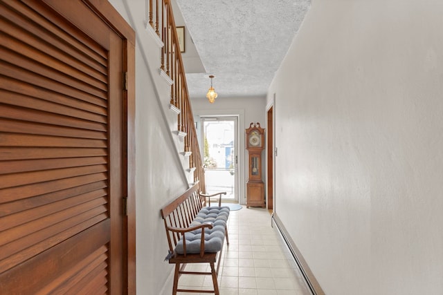 interior space featuring a textured ceiling, light tile patterned floors, and baseboard heating