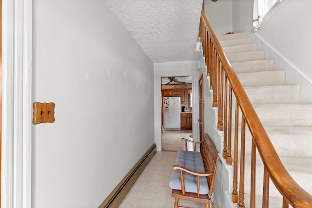 stairway featuring a textured ceiling and ceiling fan