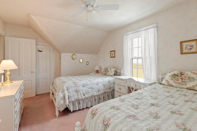 carpeted bedroom featuring a textured ceiling, vaulted ceiling, and ceiling fan