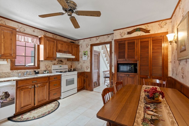 kitchen with sink, white range with gas cooktop, dishwasher, black microwave, and ornamental molding