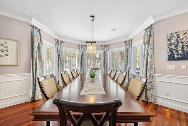 dining space featuring crown molding, a notable chandelier, and dark hardwood / wood-style flooring