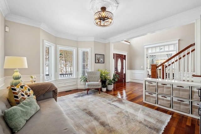 entryway with hardwood / wood-style floors, a wealth of natural light, crown molding, and a chandelier